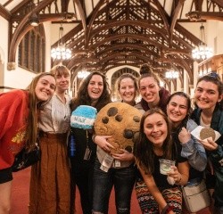Students pose in the Library with a stuffed milk carton and cookie.