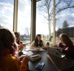 Students sitting around the table looking outside