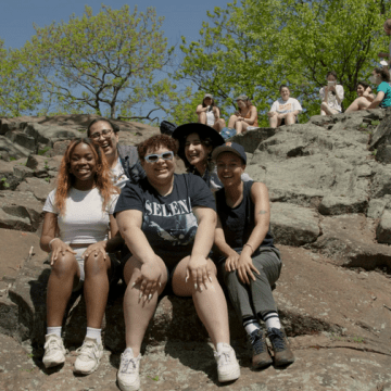 A group of students sitting near the summit of Mount Holyoke.