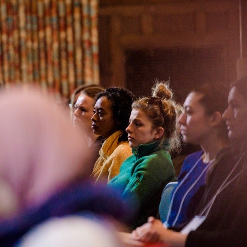 A group of diverse students listen attentively