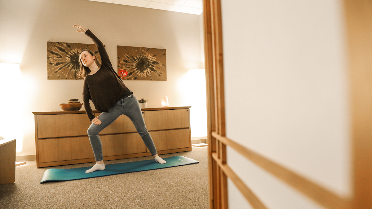 A student stretching on a yoga mat