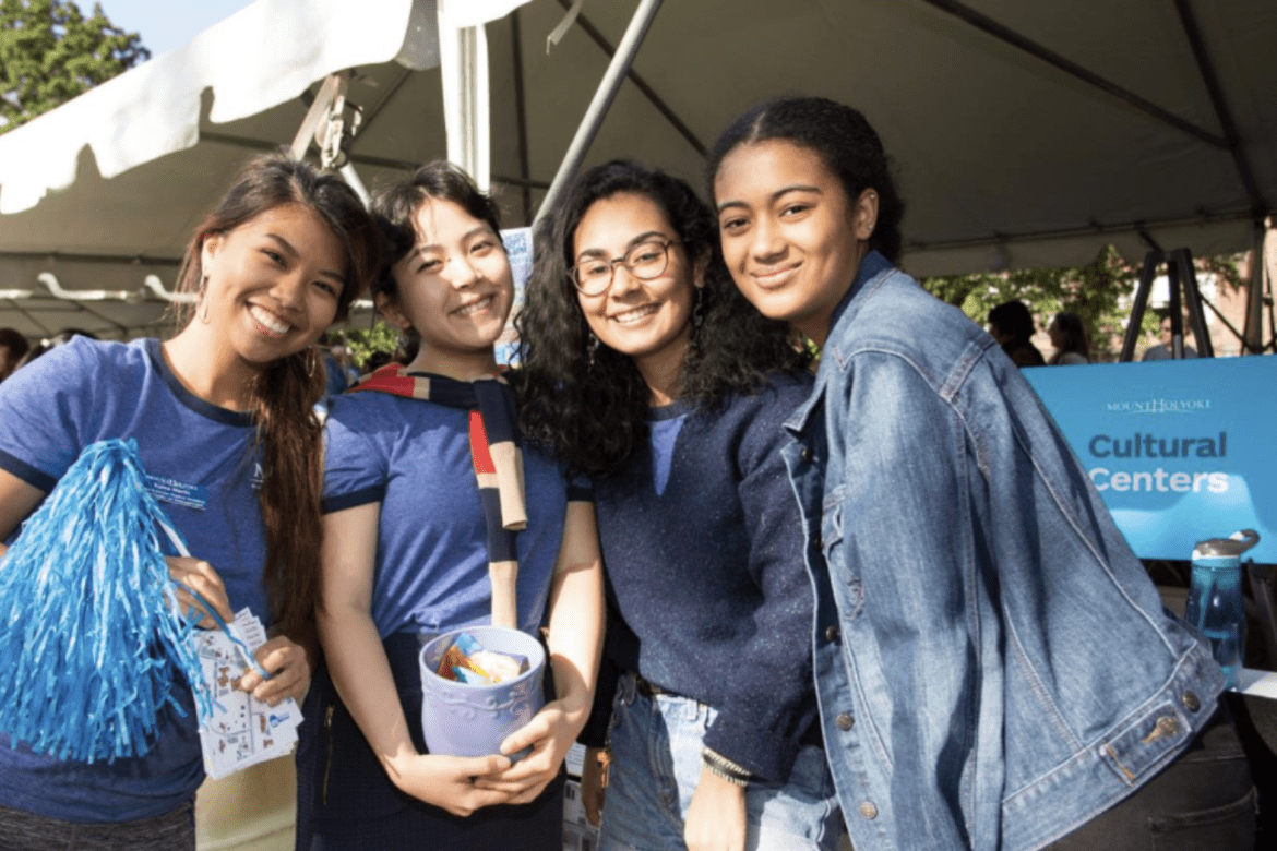 Four students working the Cultural Center table during Orientation