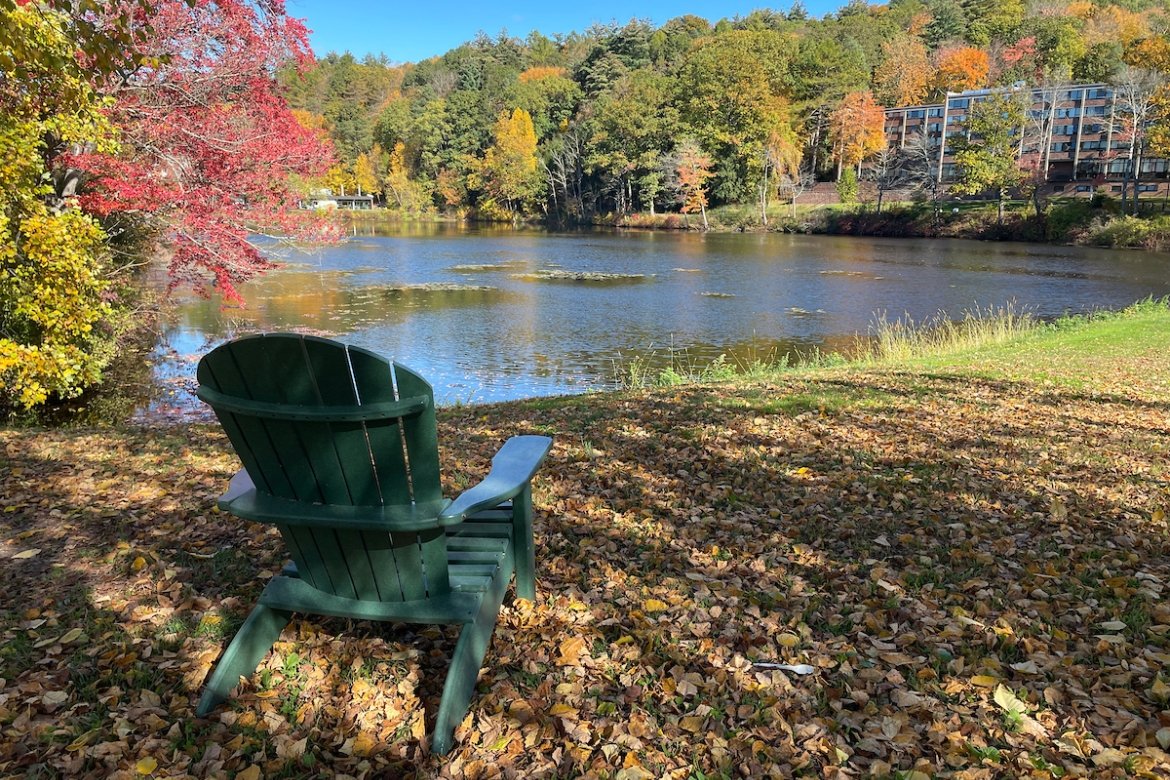 Lower lake in the fall with an Adirondack chair looking out over the water.