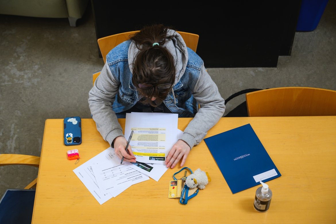 Overhead view of a student looking at paperwork at the Sophomore Institute at Mount Holyoke College.