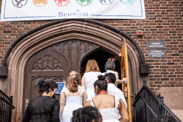 Alums walking up the steps to go into Chapin Auditorium, underneath the Welcome Home banner