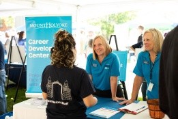 Staff from the Career Development Center talk with a student at an information table