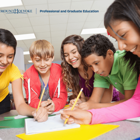 Mount Holyoke Professional and Graduate Education - students in a group smiling and writing on paper