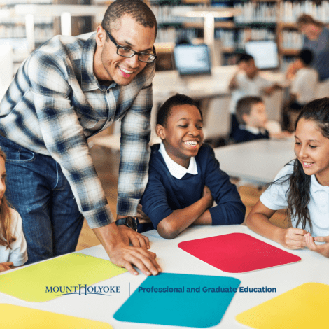 Students in a circle looking at colored pieces of paper.