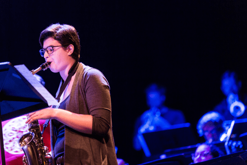 A student playing the saxophone in a concert