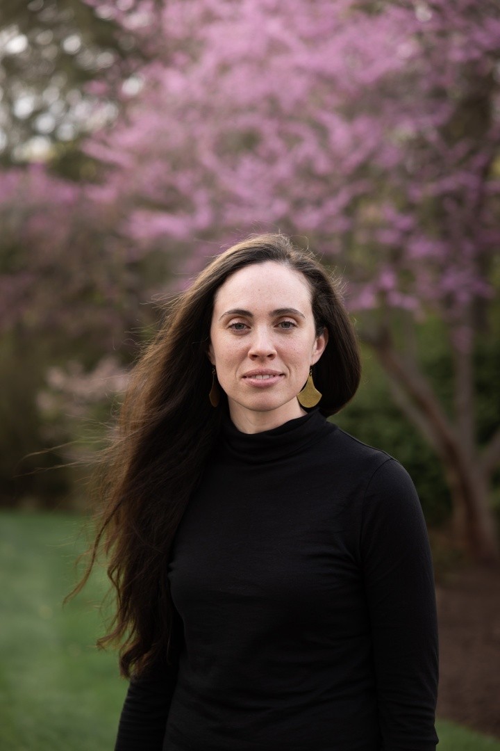 Caitlin Lambert ’09 in front of a pink flowering bush on the Mount Holyoke College campus.