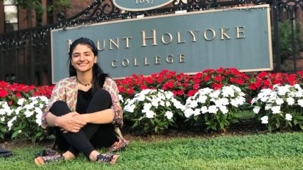 Ahlaam Abbasi by the Mount Holyoke College sign.