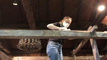 Erin Hancock cleaning a 200-year-old loom with wood cleaner and linseed oil.