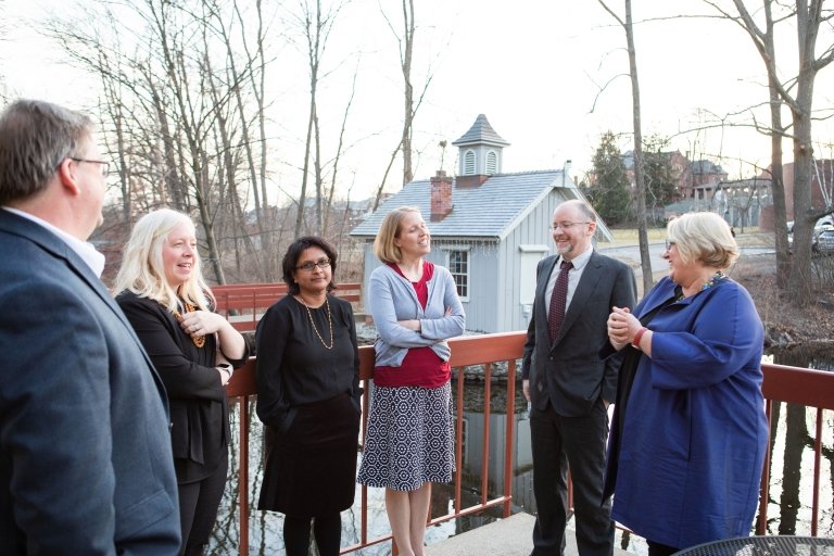 Sonya Stephens, Jon Western and the Faculty Award winners casually chatting on a deck overlooking a stream.