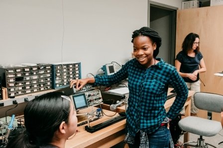 Students talking, with some electronics on the table next to them in the Fimbel Maker & Innovation Lab