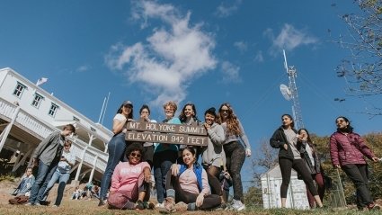 A group of students poses at the summit sign on the top of Mount Holyoke on Mountain Day 2018.