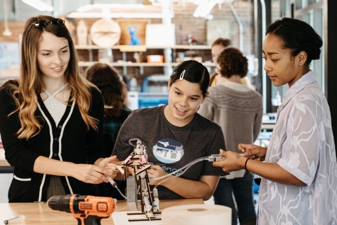 Three students in the Fimbel Maker & Innovation Lab working with circuitry.