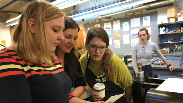 Tori Gernert-Dott ’20 examines a print with Christine Andrews and Amanda Maciuba while Rebecca Grossman ’18 looks on