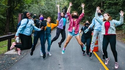 Students jumping together on mountain day.