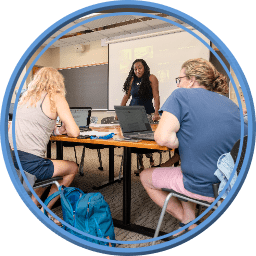 Independent Schools Pedagogy: A teacher and two students around laptops